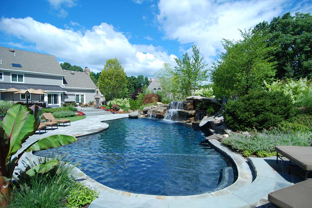 inground pool with house in background